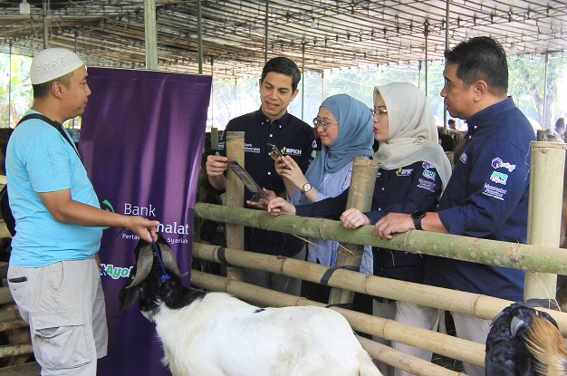Sekretaris Perusahaan Muamalat Hayunaji (kedua kiri) bersama Region Head Jakarta West Erick Ermawan (kanan) dan Branch Manager Bank Muamalat Bintaro Jaya Melinawati Amran (kedua kanan) menyaksikan nasabah melakukan pembelian hewan kurban menggunakan fitur QRIS Muamalat DIN di salah satu pusat penjualan hewan di Bintaro Jaya, Tangerang Selatan, Kamis (15/6/2023). Foto: humas BSI